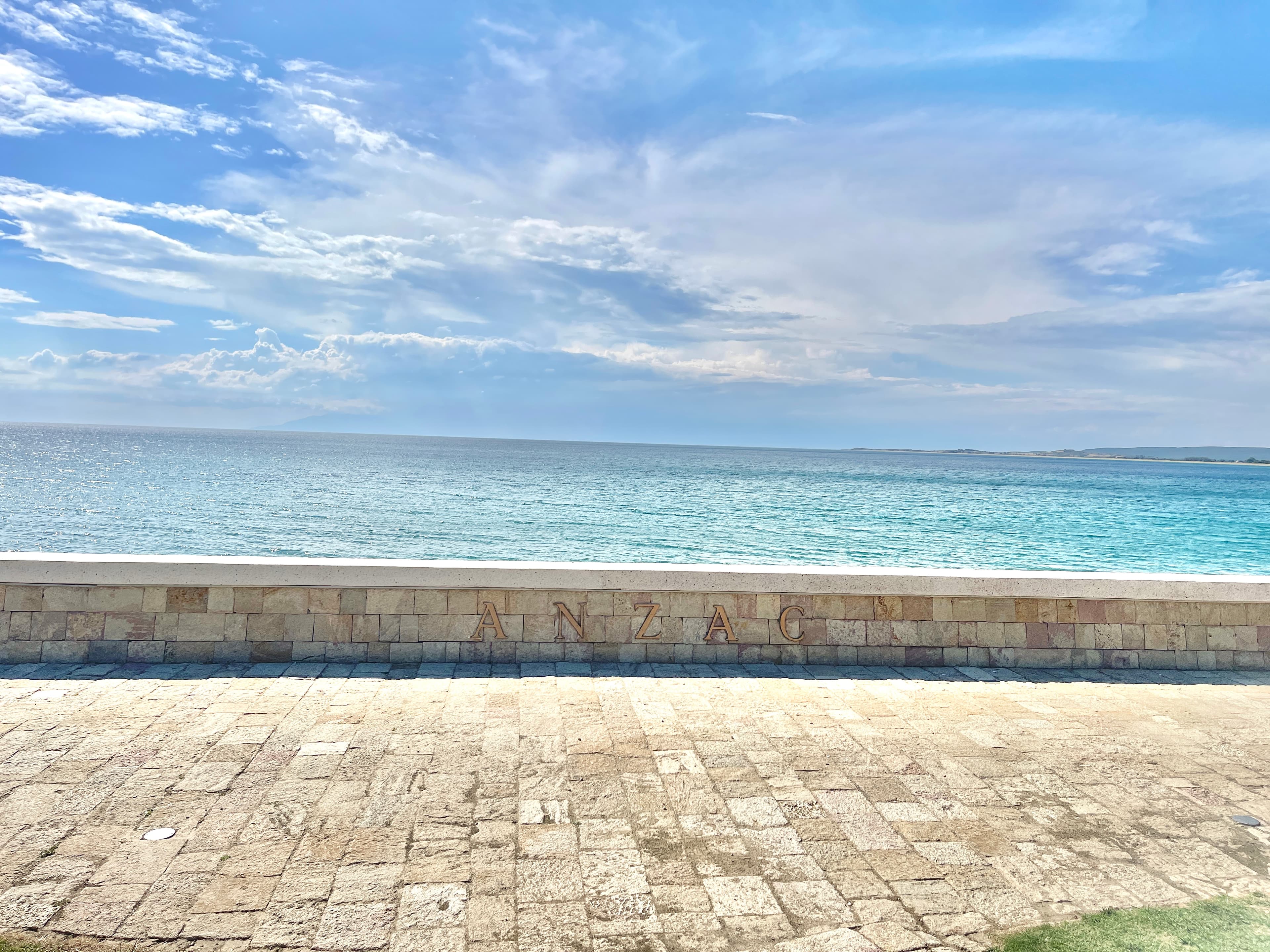 The ANZAC sea wall at Anzac Cove on the Gallipoli peninsula — 'ANZAC' carved in stone above the turquoise Aegean.