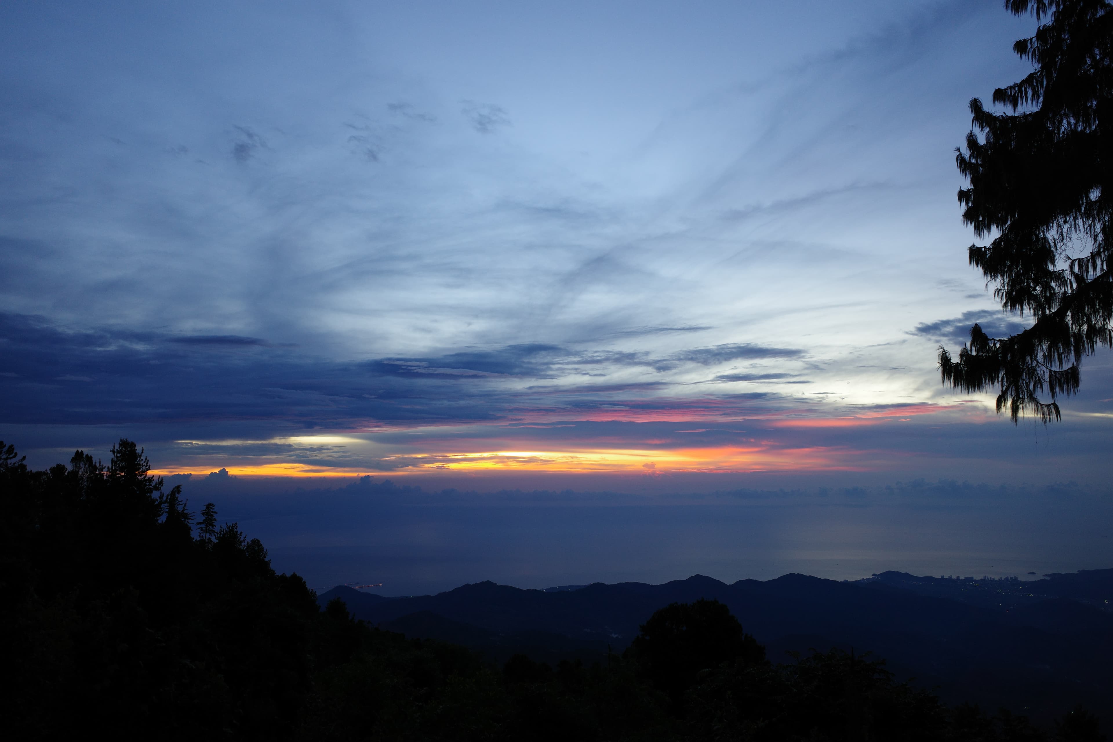 Latin American sunset over silhouetted mountains — the moment every long traveller remembers.